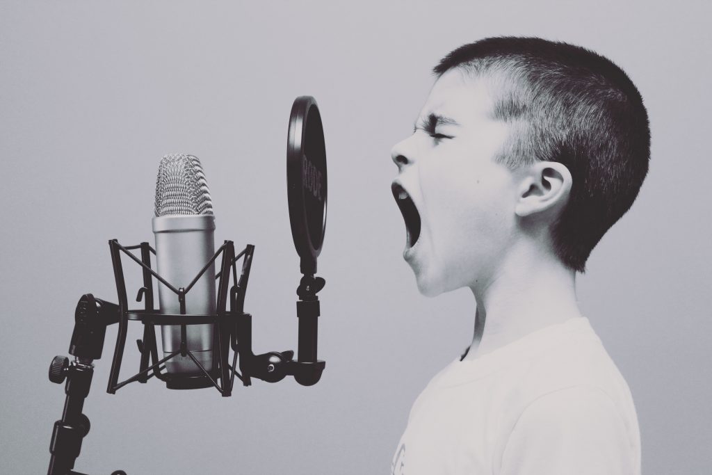 Kind singt in Mikrophone